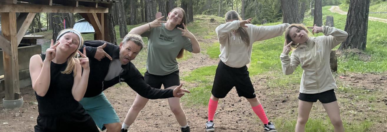 Quatre jeunes et un encadrant posant dans une clairière